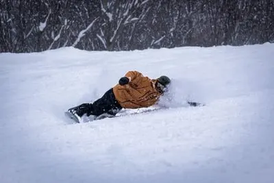 A snowboarder carving through deep powder on a Canyons lesson